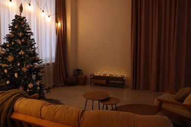 Photo of Tv area with cabinet, comfortable furniture and Christmas tree in stylish room