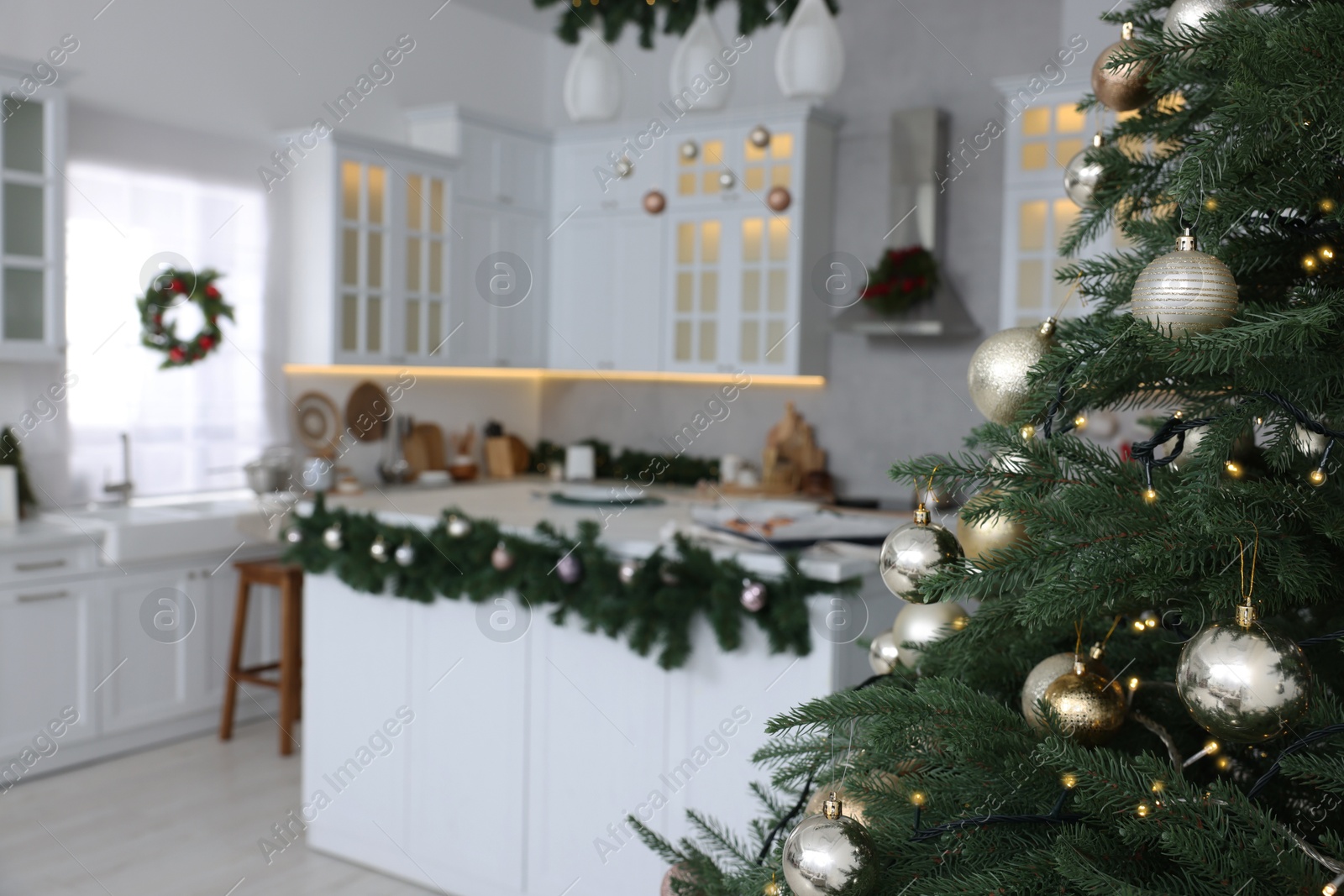 Photo of Closeup view of beautiful decorated Christmas tree in kitchen. Space for text