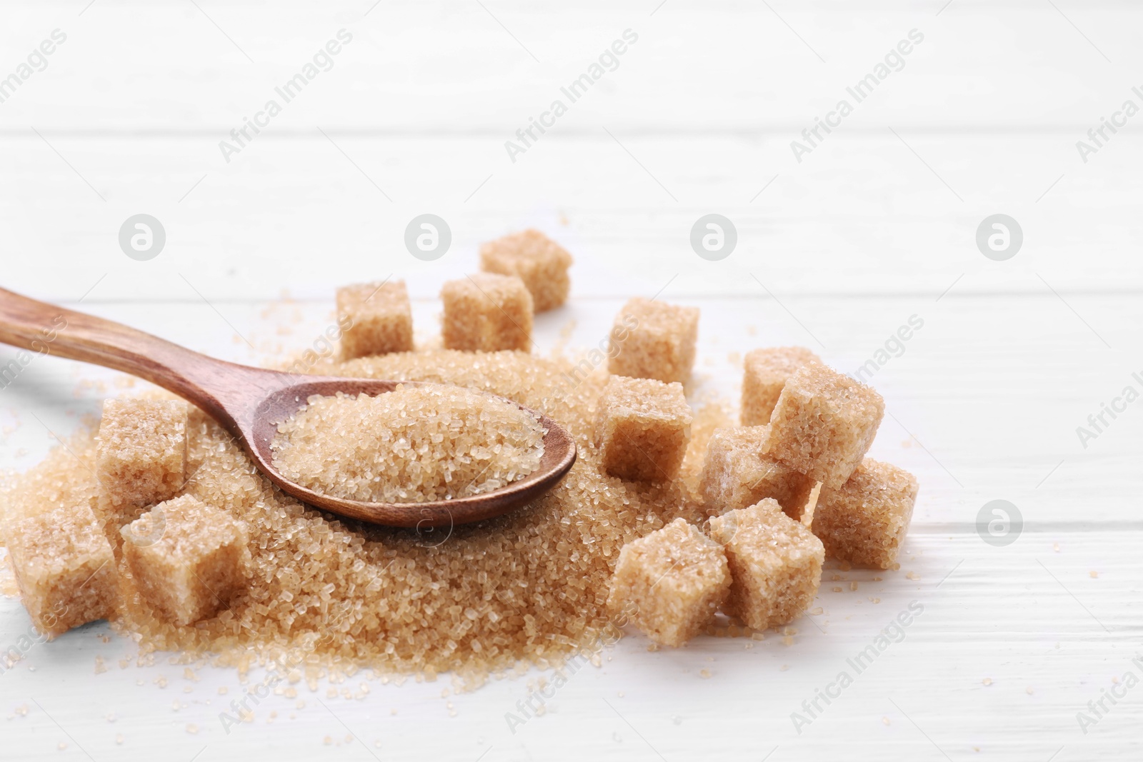 Photo of Different types of brown sugar on white wooden table