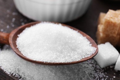 Photo of White granulated sugar in spoon, closeup view