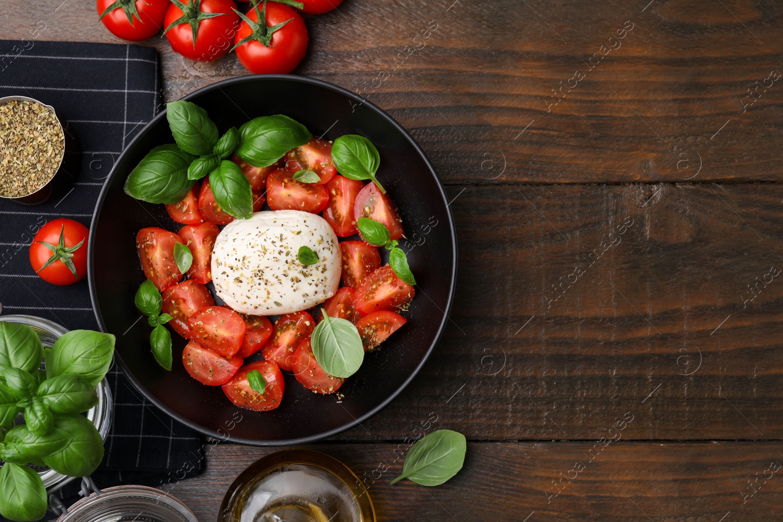 Photo of Tasty salad Caprese with mozarella, tomatoes and basil on wooden table, flat lay. Space for text