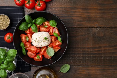 Photo of Tasty salad Caprese with mozarella, tomatoes and basil on wooden table, flat lay. Space for text