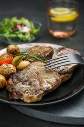 Photo of Tasty beef tongue pieces, rosemary and potatoes on grey table, closeup