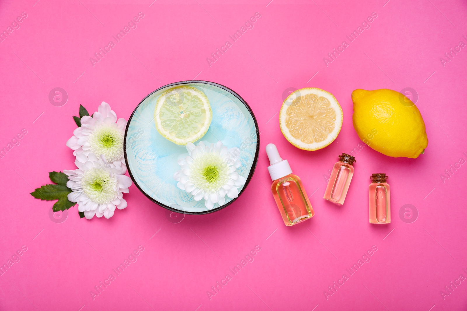 Photo of Flat lay composition with bowl of water, flowers and lemons on pink background. Spa treatment