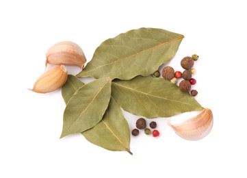 Aromatic bay leaves, garlic and peppercorns on white background, top view