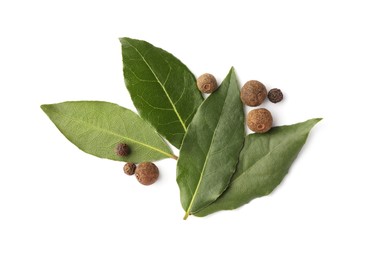 Photo of Fresh green bay leaves and peppercorns on white background, top view