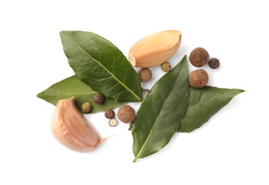 Fresh green bay leaves, garlic and peppercorns on white background, top view