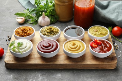 Photo of Many different sauces and products on grey table
