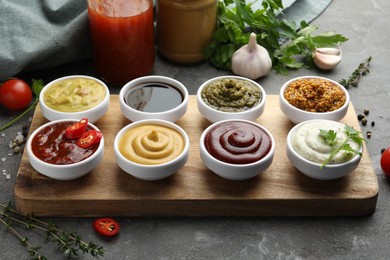 Photo of Many different sauces and products on grey table