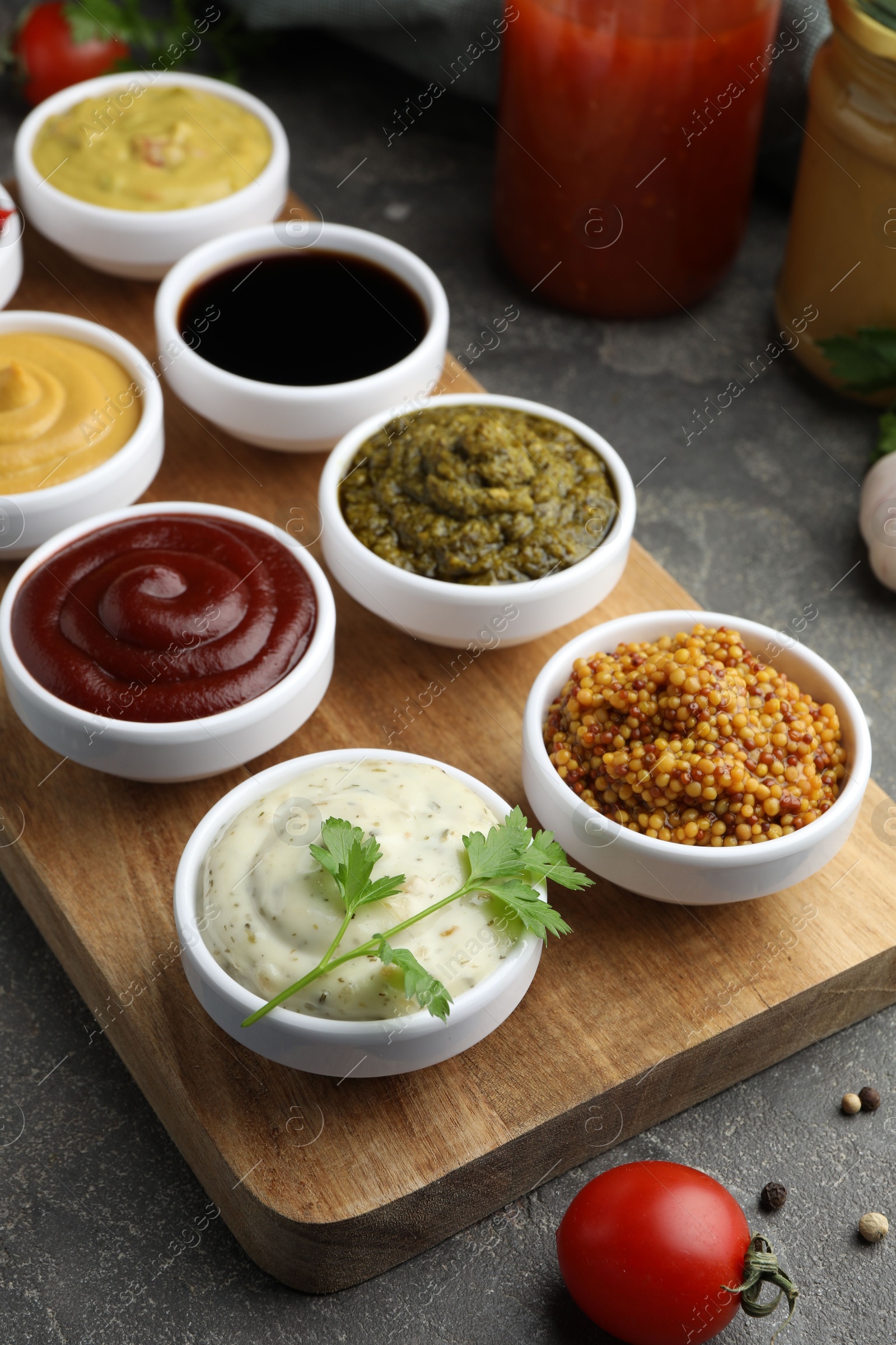 Photo of Many different sauces and products on grey table