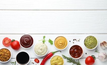 Photo of Many different sauces, spices and vegetables on white wooden table, flat lay. Space for text