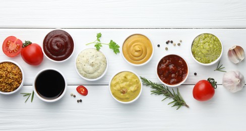 Photo of Many different sauces, spices and vegetables on white wooden table, flat lay
