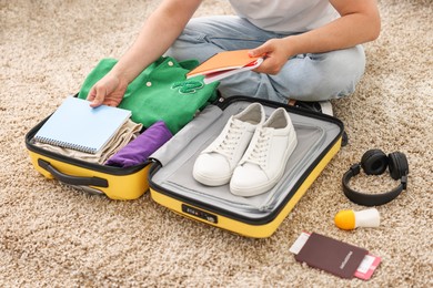 Man packing suitcase on floor at home, closeup