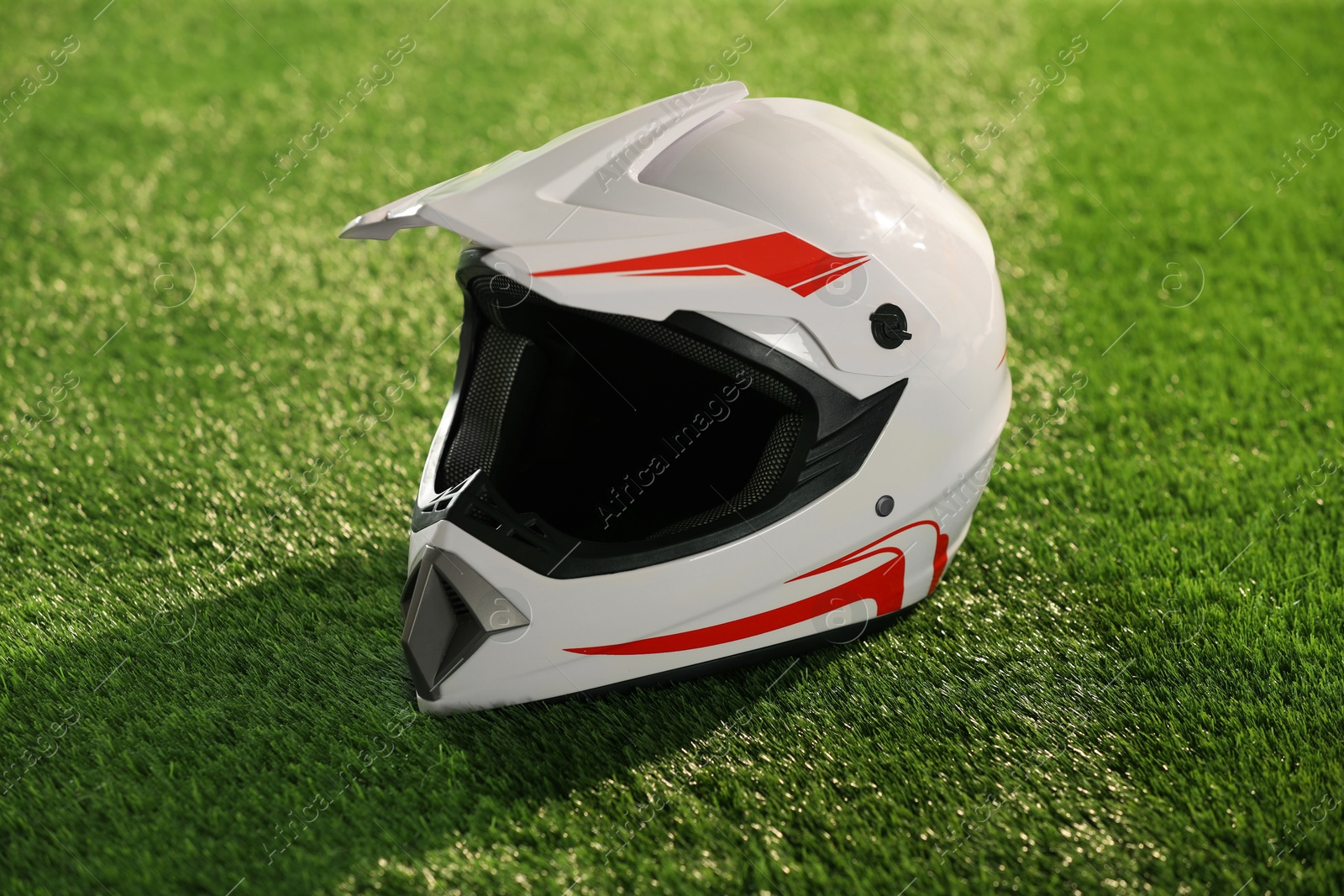 Photo of Modern motorcycle helmet with visor on green grass