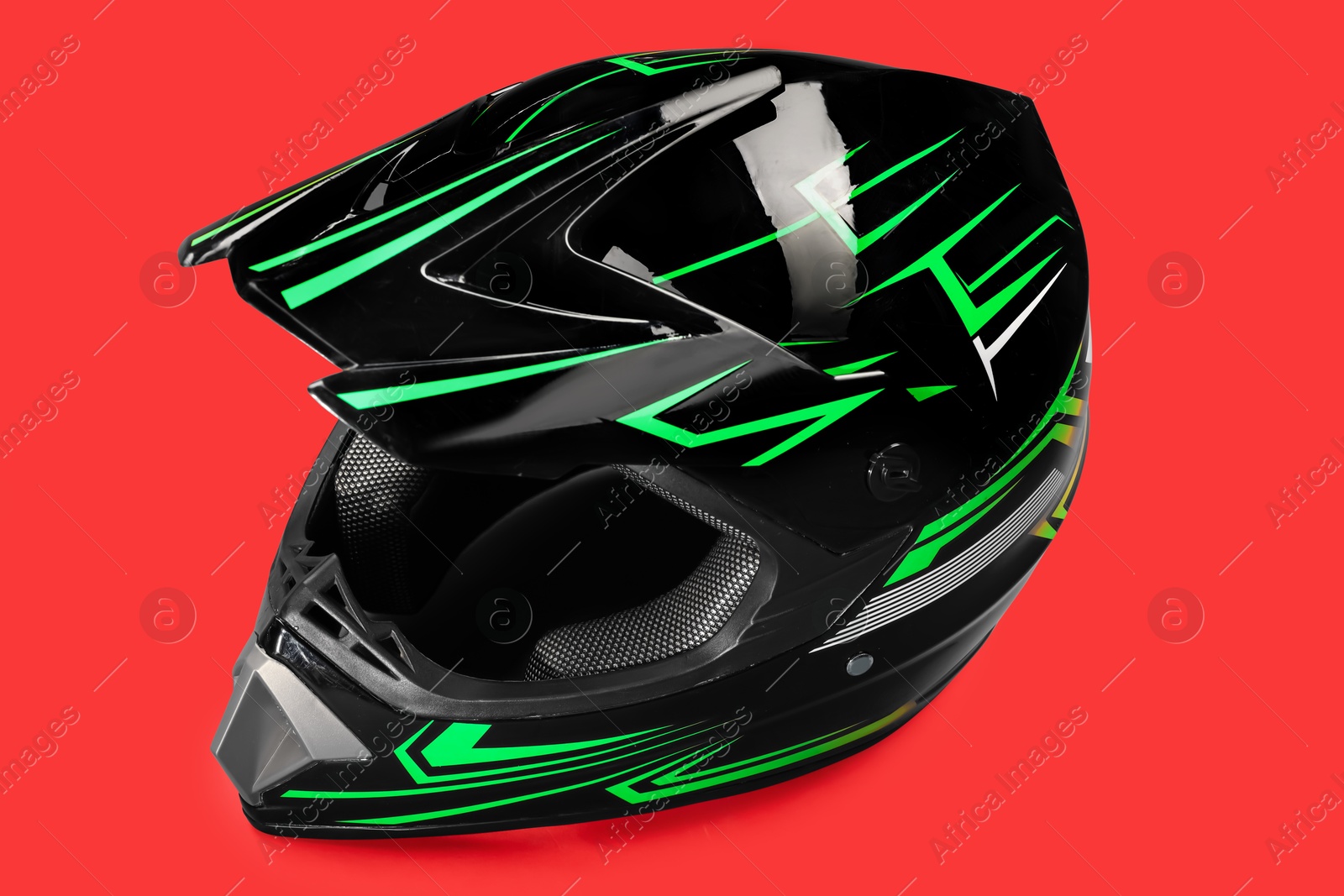 Photo of Modern motorcycle helmet with visor on red background