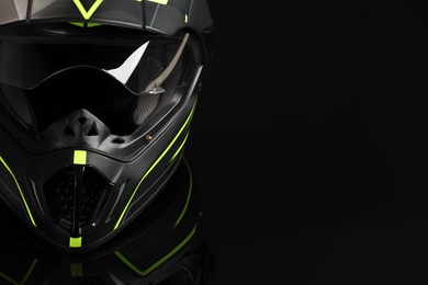 Photo of Modern motorcycle helmet with visor on black background, closeup. Space for text