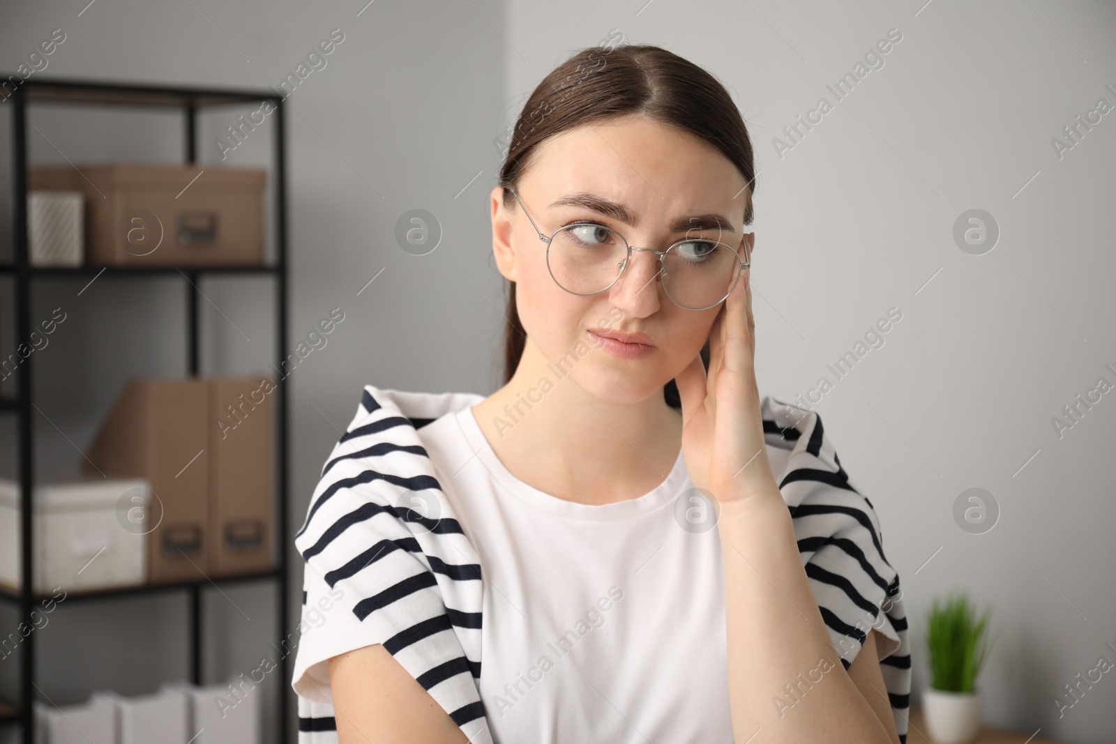 Photo of Portrait of embarrassed woman in glasses in office