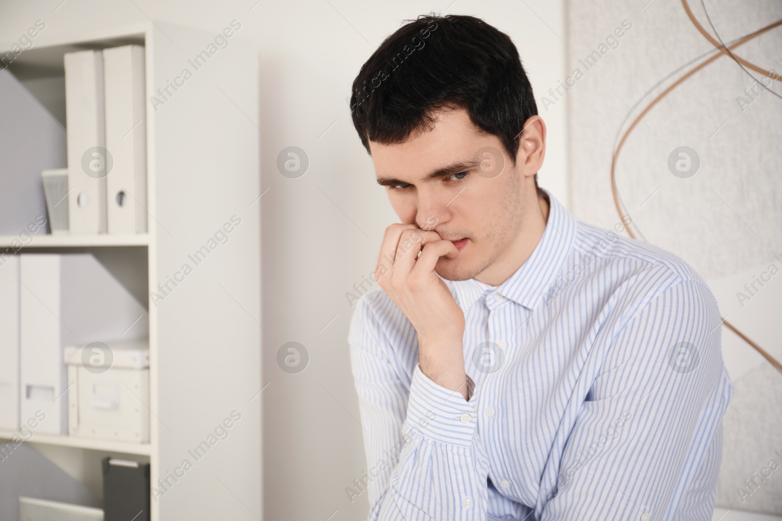 Photo of Portrait of embarrassed young man in office