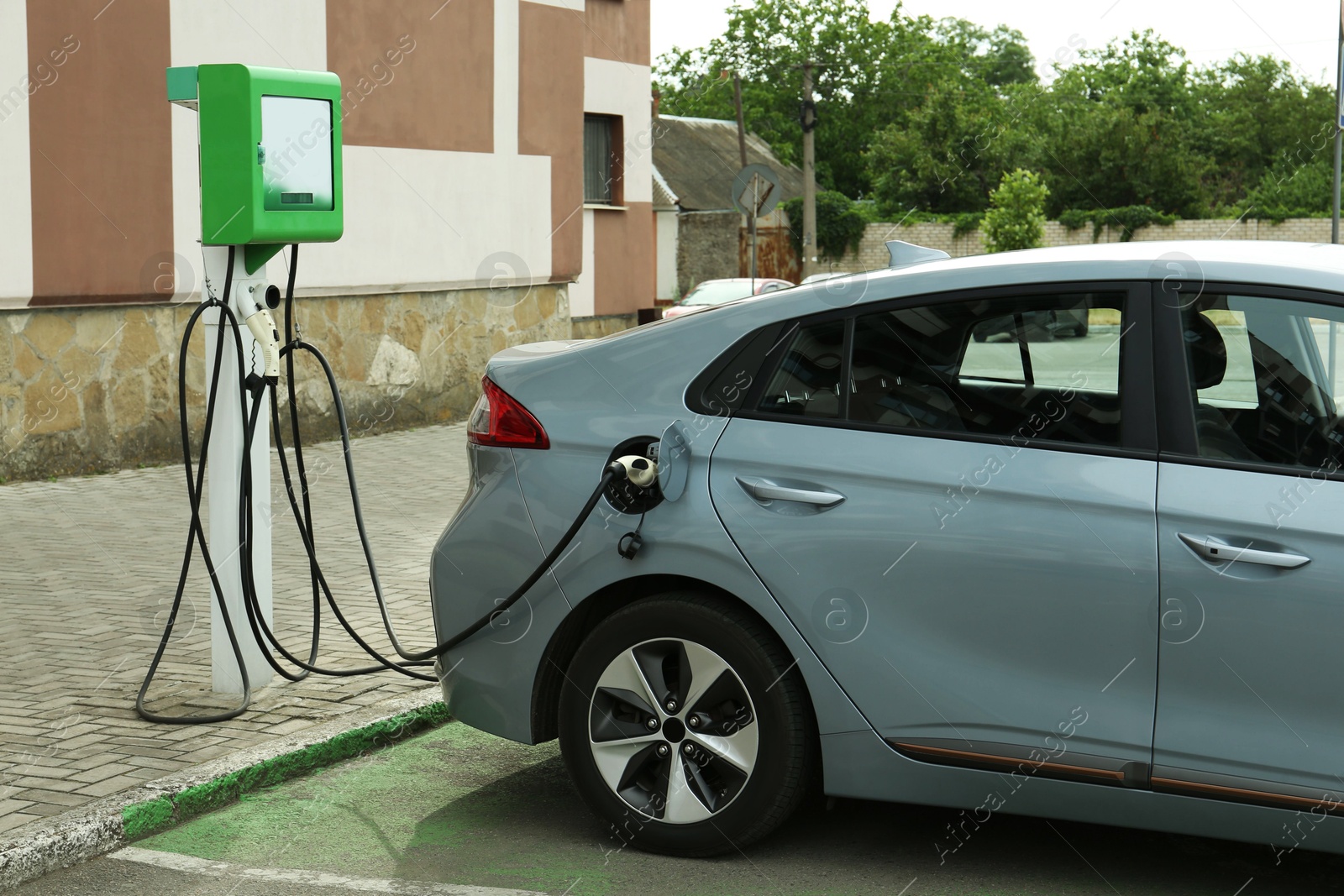 Photo of Modern electric car charging from station outdoors