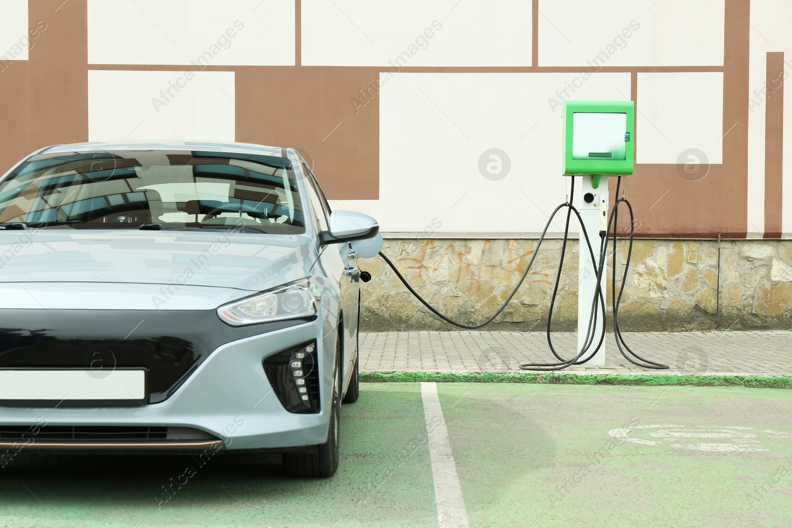 Photo of Modern electric car charging from station outdoors