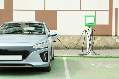 Photo of Modern electric car charging from station outdoors