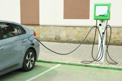 Photo of Modern electric car charging from station outdoors