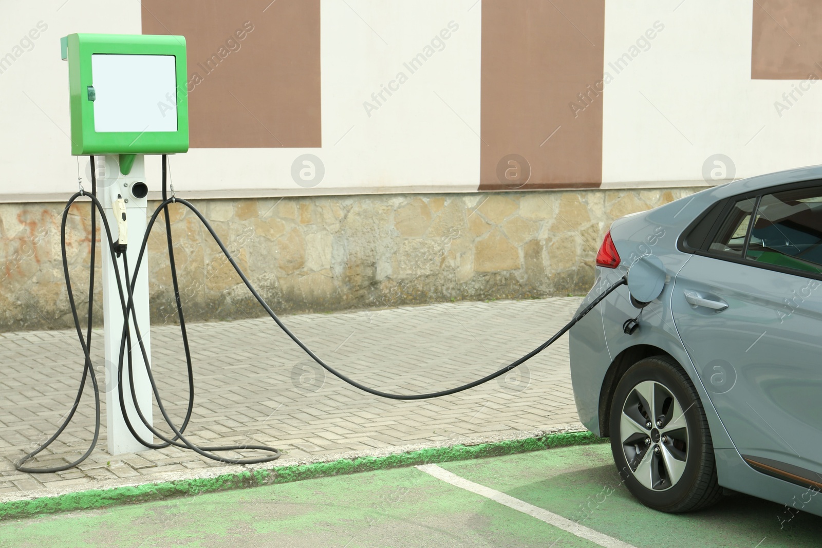 Photo of Modern electric car charging from station outdoors