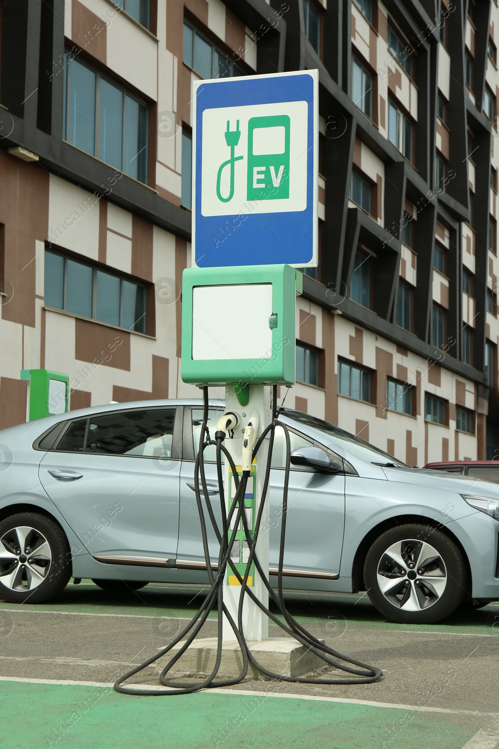 Photo of Modern electric car charging from station outdoors