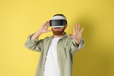 Photo of Man using virtual reality headset on pale yellow background