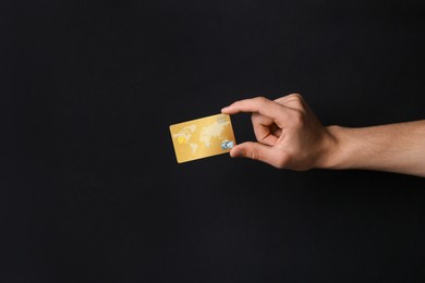 Photo of Man holding credit card on black background, closeup