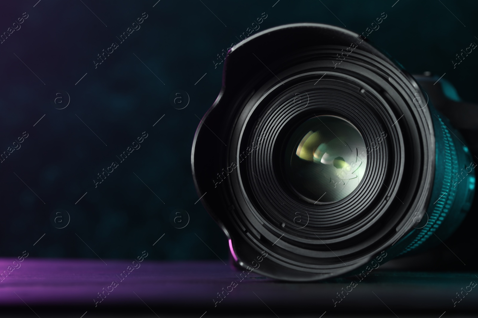 Photo of Modern photo camera on black table, space for text