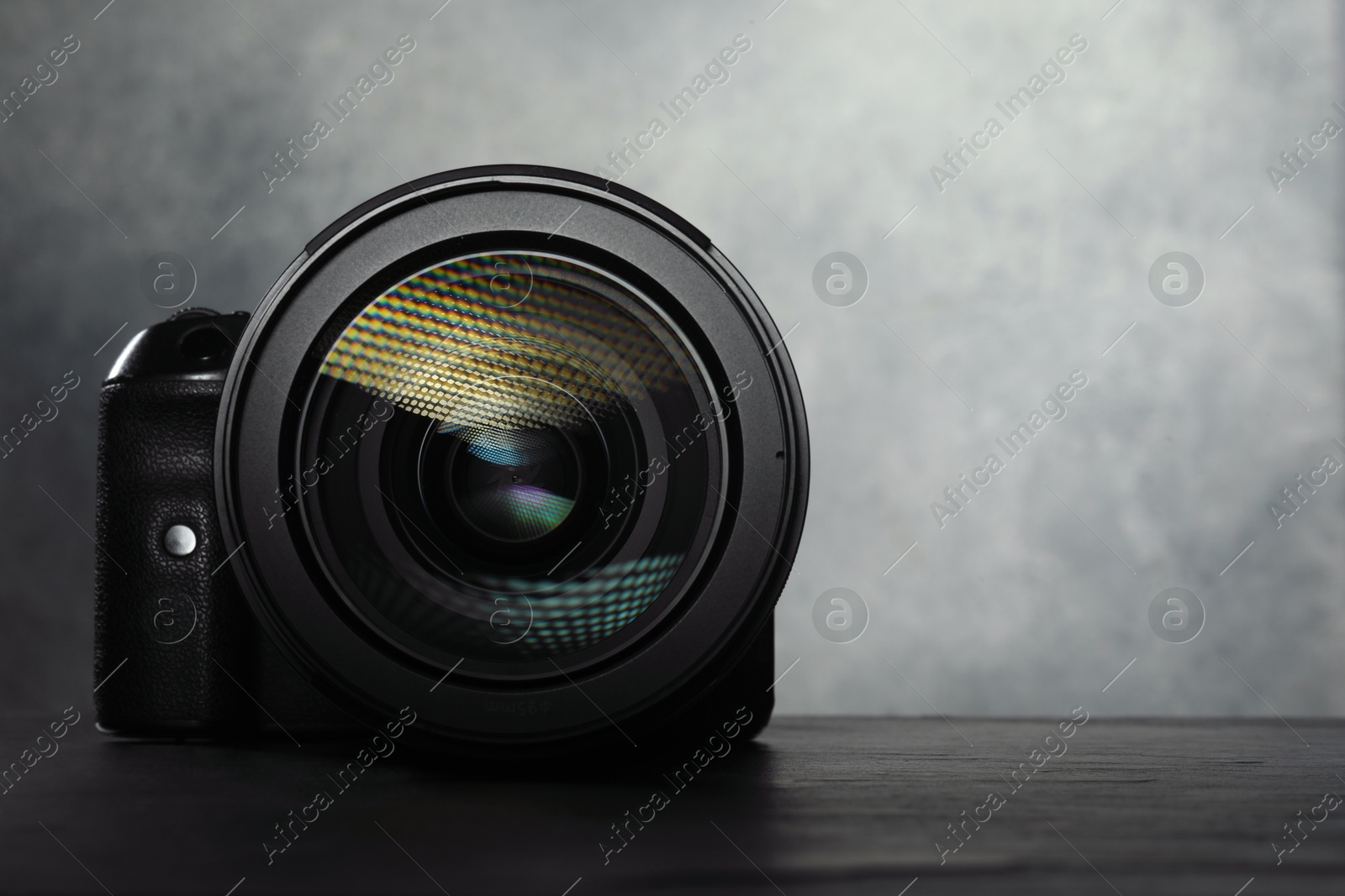 Photo of Modern photo camera on black table, space for text