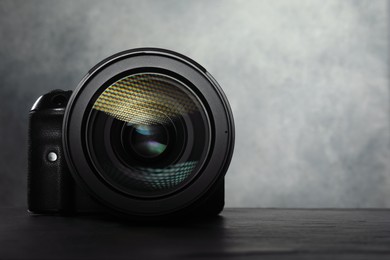 Photo of Modern photo camera on black table, space for text