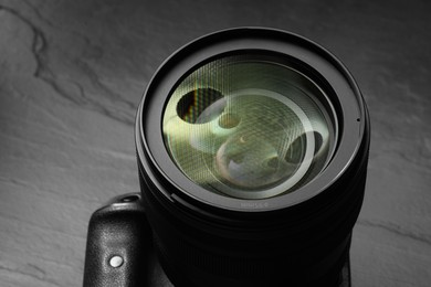 Modern photo camera on black table, closeup