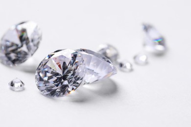 Photo of Many beautiful shiny diamonds on white background, closeup