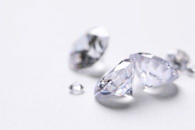 Photo of Many beautiful shiny diamonds on white background, closeup