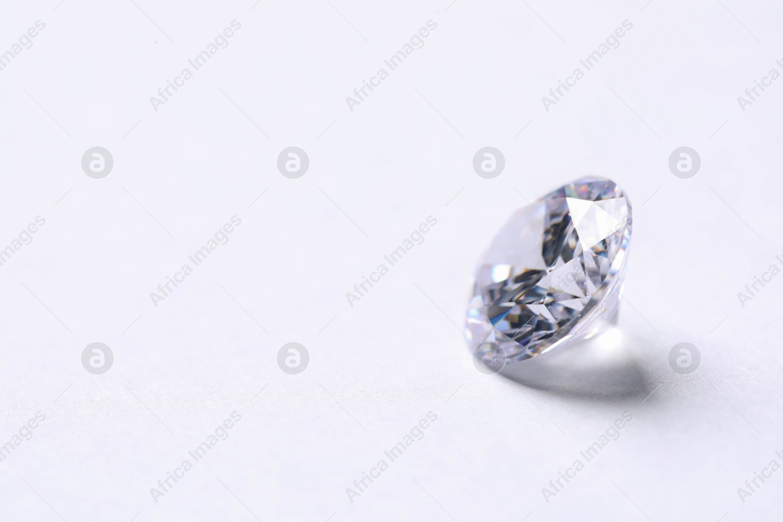 Photo of One beautiful shiny diamond on white background, closeup. Space for text