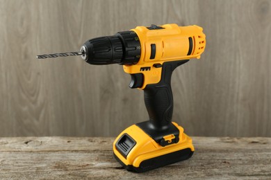 Photo of One cordless electric drill on wooden table