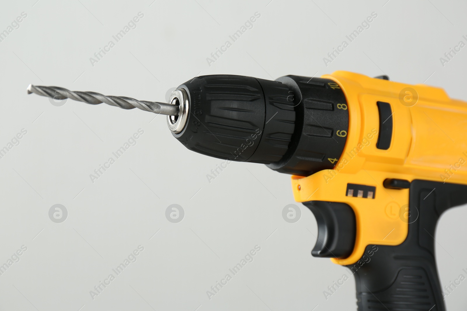 Photo of One cordless electric drill on light grey background