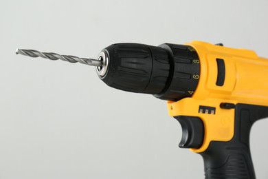 Photo of One cordless electric drill on light grey background