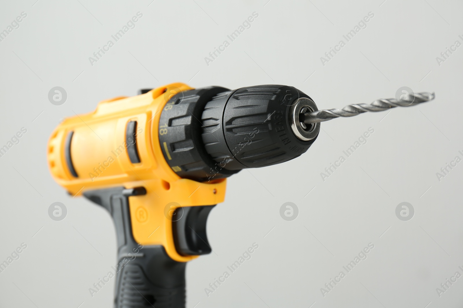 Photo of One cordless electric drill on light grey background