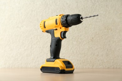 Photo of One cordless electric drill on wooden surface