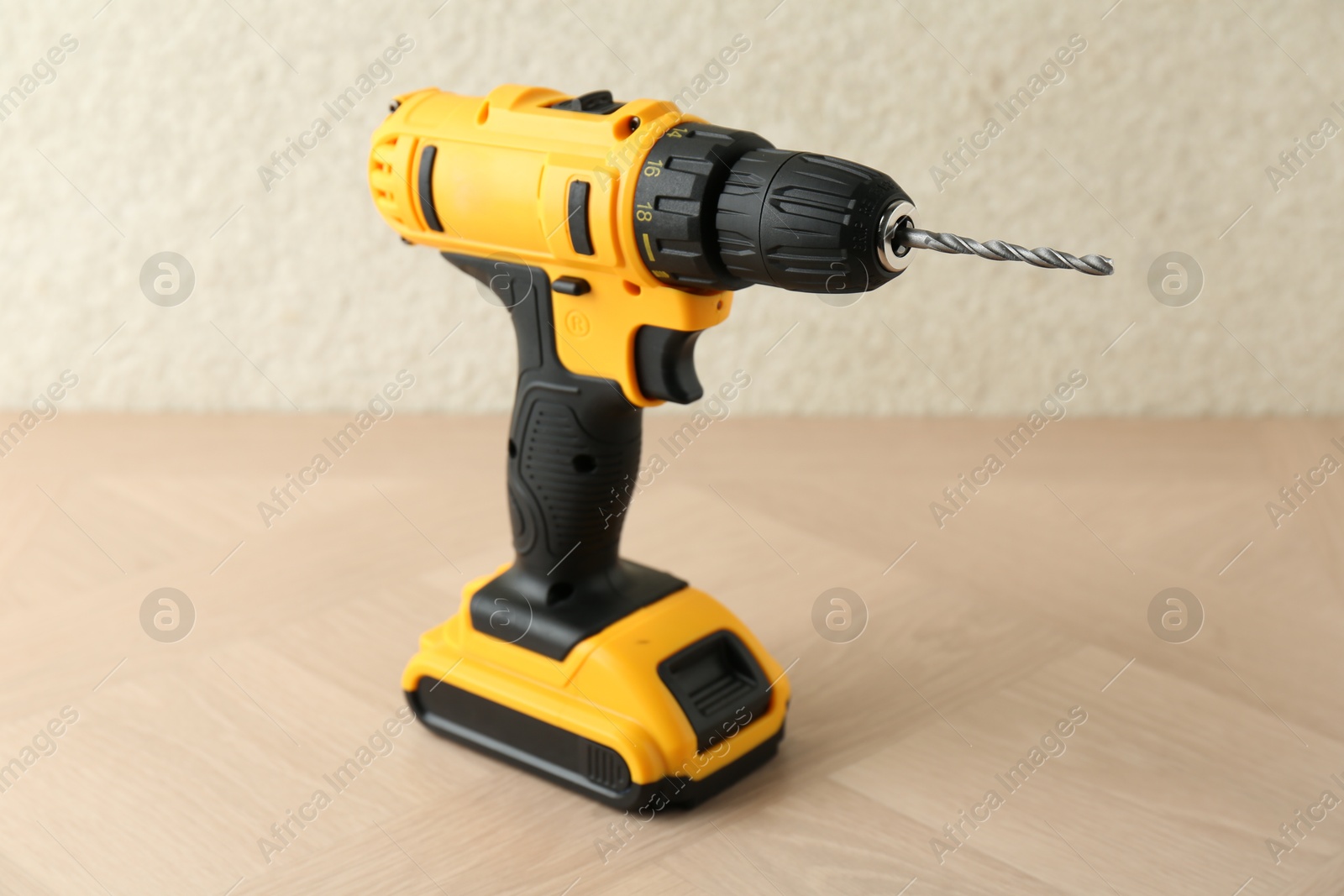 Photo of One cordless electric drill on wooden surface