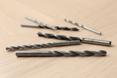 Many different drill bits on wooden surface