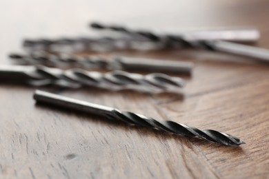 Many different drill bits on wooden surface