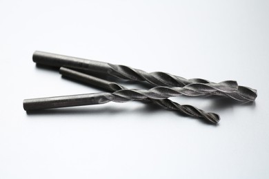 Photo of Different drill bits on light grey background