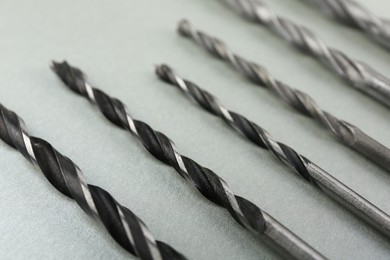 Many different drill bits on light grey background