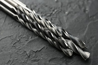 Photo of Many different drill bits on grey table, closeup