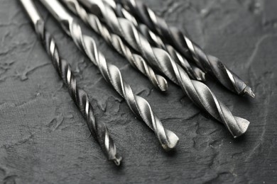 Photo of Many different drill bits on grey table, closeup