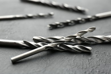 Many different drill bits on grey table, closeup